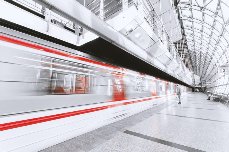 Train travelling through modern light railway terminal