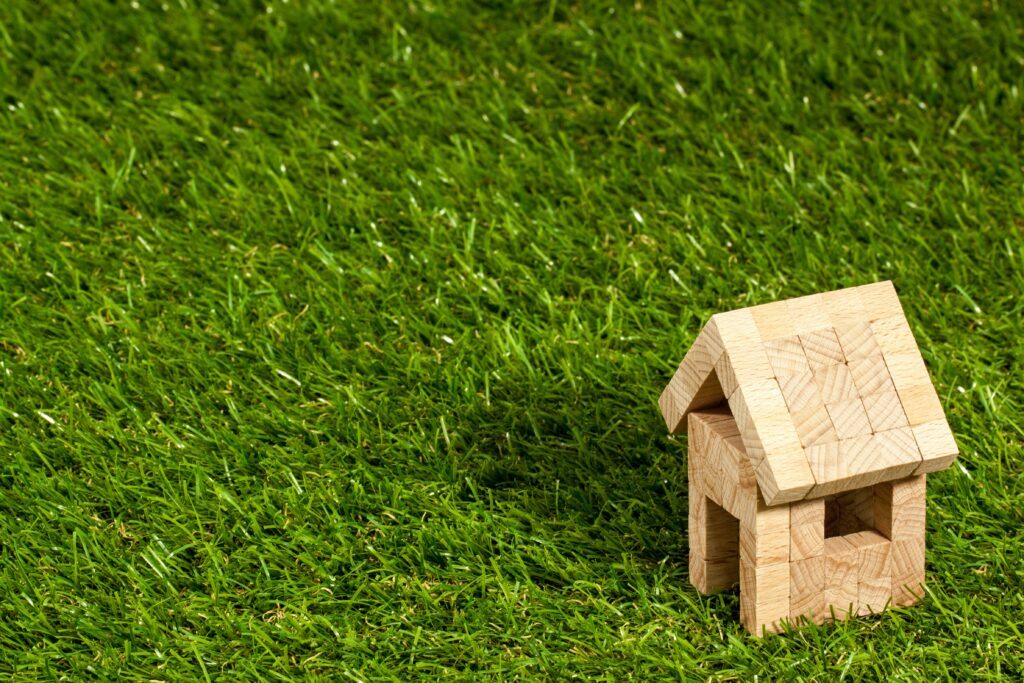 Wooden block toy rental house on grass