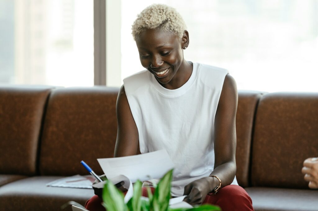 Lady sitting on sofa looking at paperwork; smiling