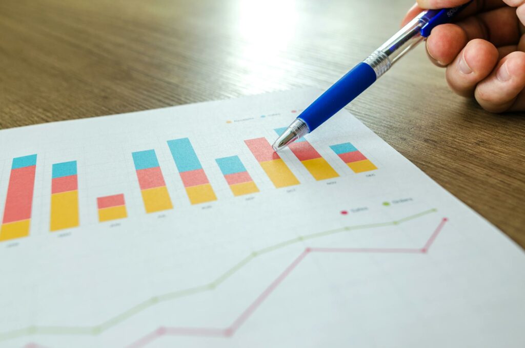 Pen pointing at coloured bar chart