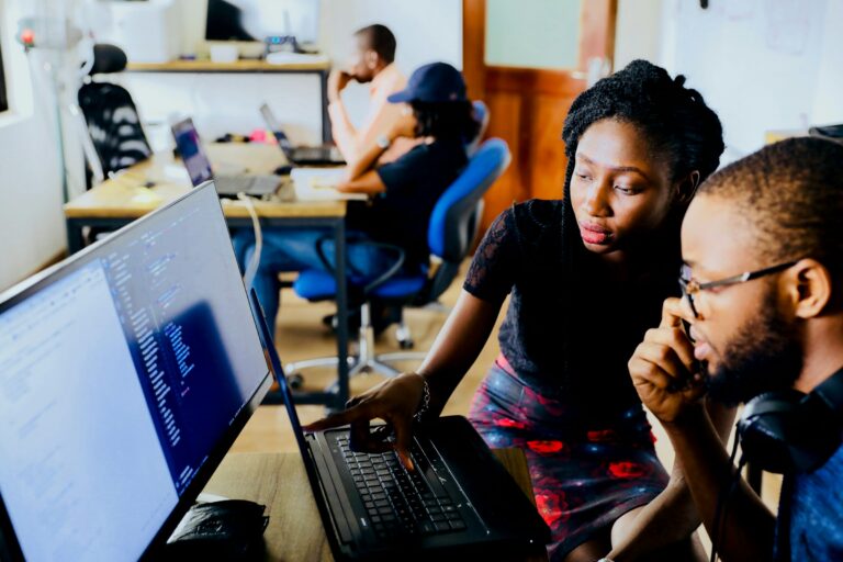 Man and woman in an office, looking at a computer screen.