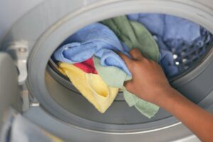 Hand pulling towels out of a washing machine