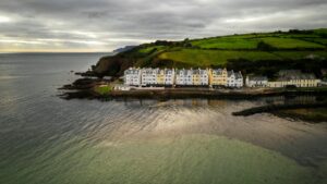 A row of white and yellow buildings along the coastline at Cushendun, Ballymena, Northern Ireland