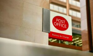 A red and white Post Office sign with "Bureau de Change" written below it.