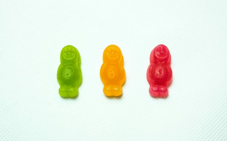 The image shows three gummy sweets in the colours of a traffic light - green, orange, and red. The arrangement and colours resemble a traffic light sequence.